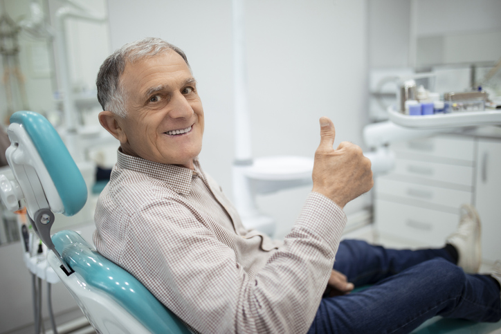 Senior man smiling as he sits in a dentist chair